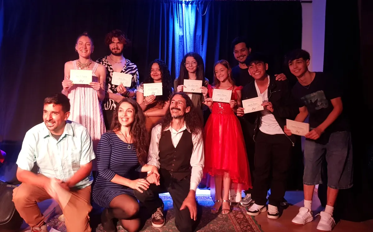 Grupo mostrando diplomas en el escenario